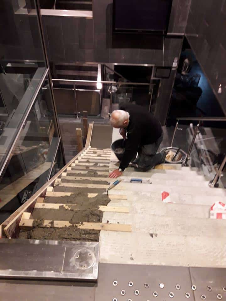 En mann som lager trapp av betong